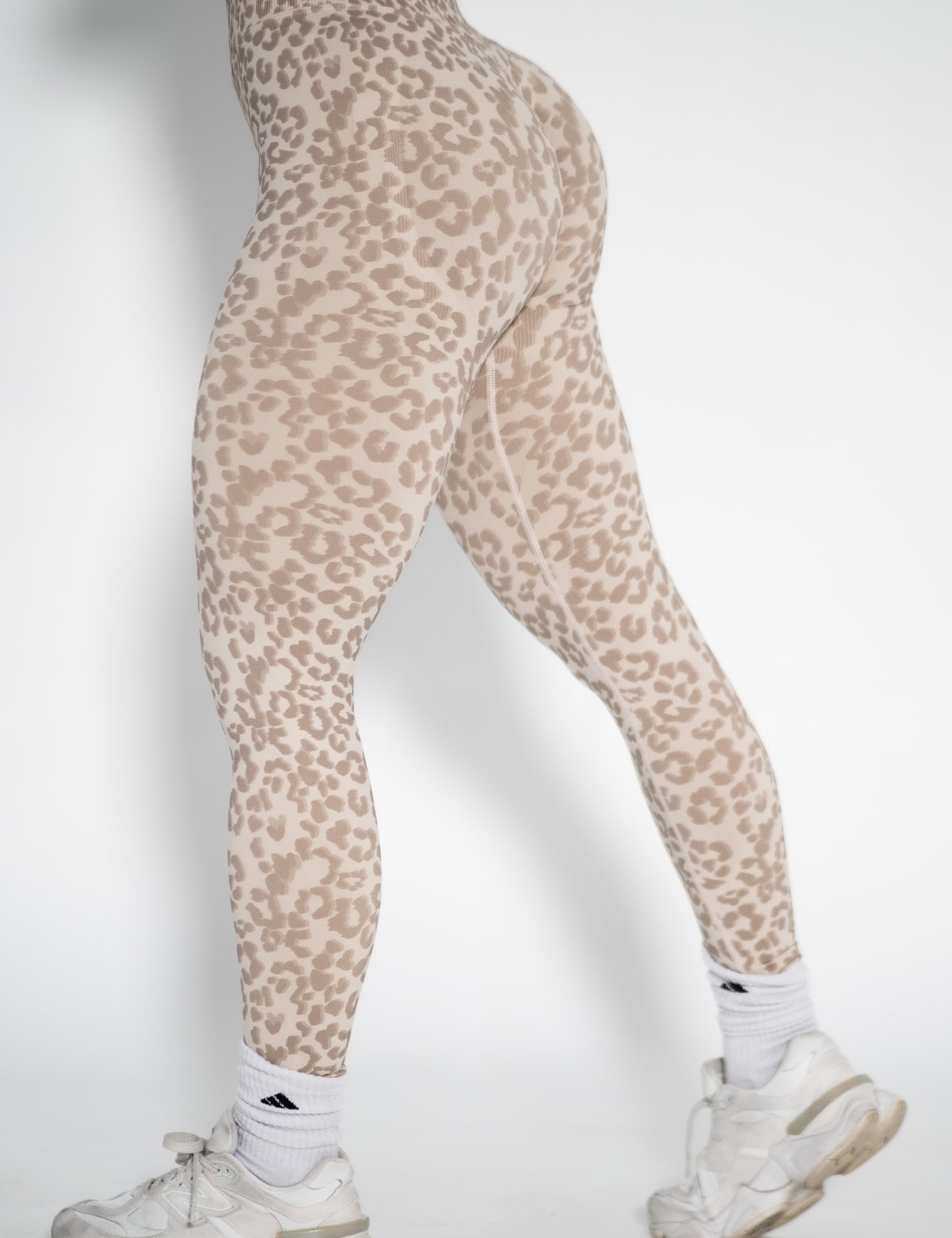 Leopard print leggings worn by a person on a white background