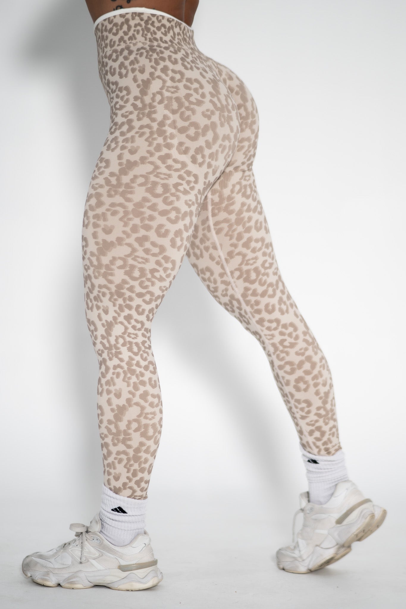 Leopard print leggings worn by a person on a white background