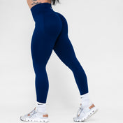 Navy blue leggings worn by a person on a white background