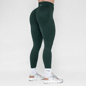 Person wearing dark green leggings on a white background
