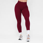 Maroon leggings worn by a person on a white background