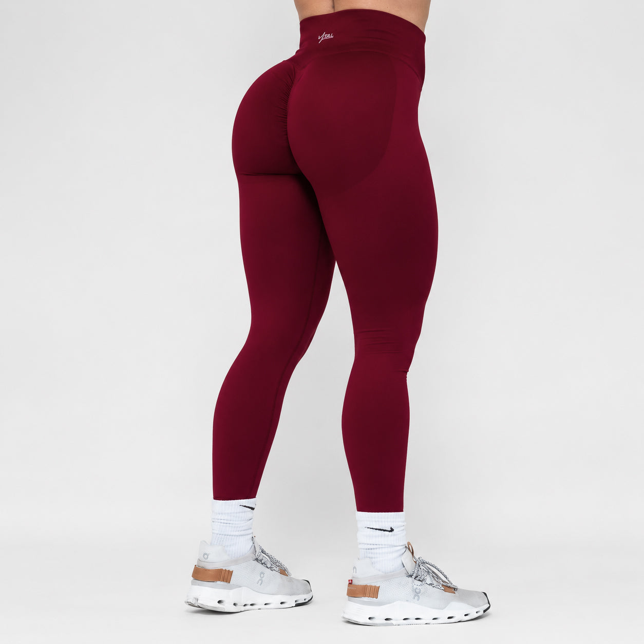 Maroon leggings worn by a person on a white background