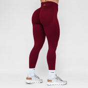 Maroon leggings worn by a person on a white background