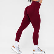 Maroon leggings worn by a person on a white background
