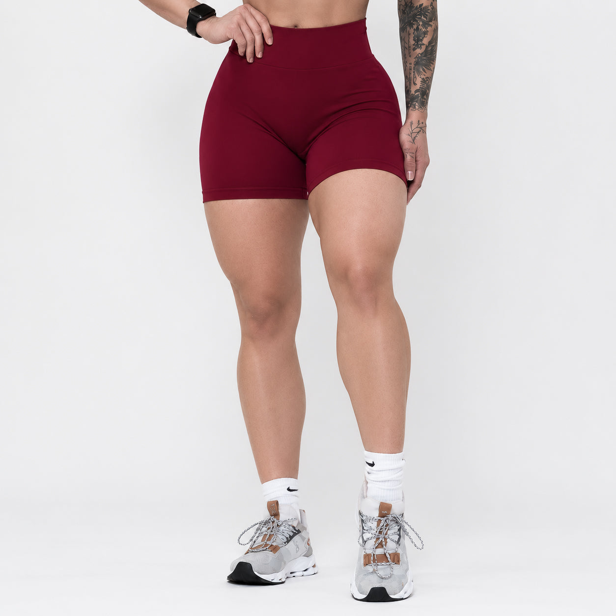 Person wearing maroon athletic shorts on a white background