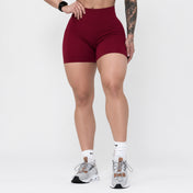 Person wearing maroon athletic shorts on a white background