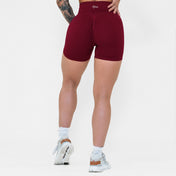 Person wearing maroon shorts on a white background
