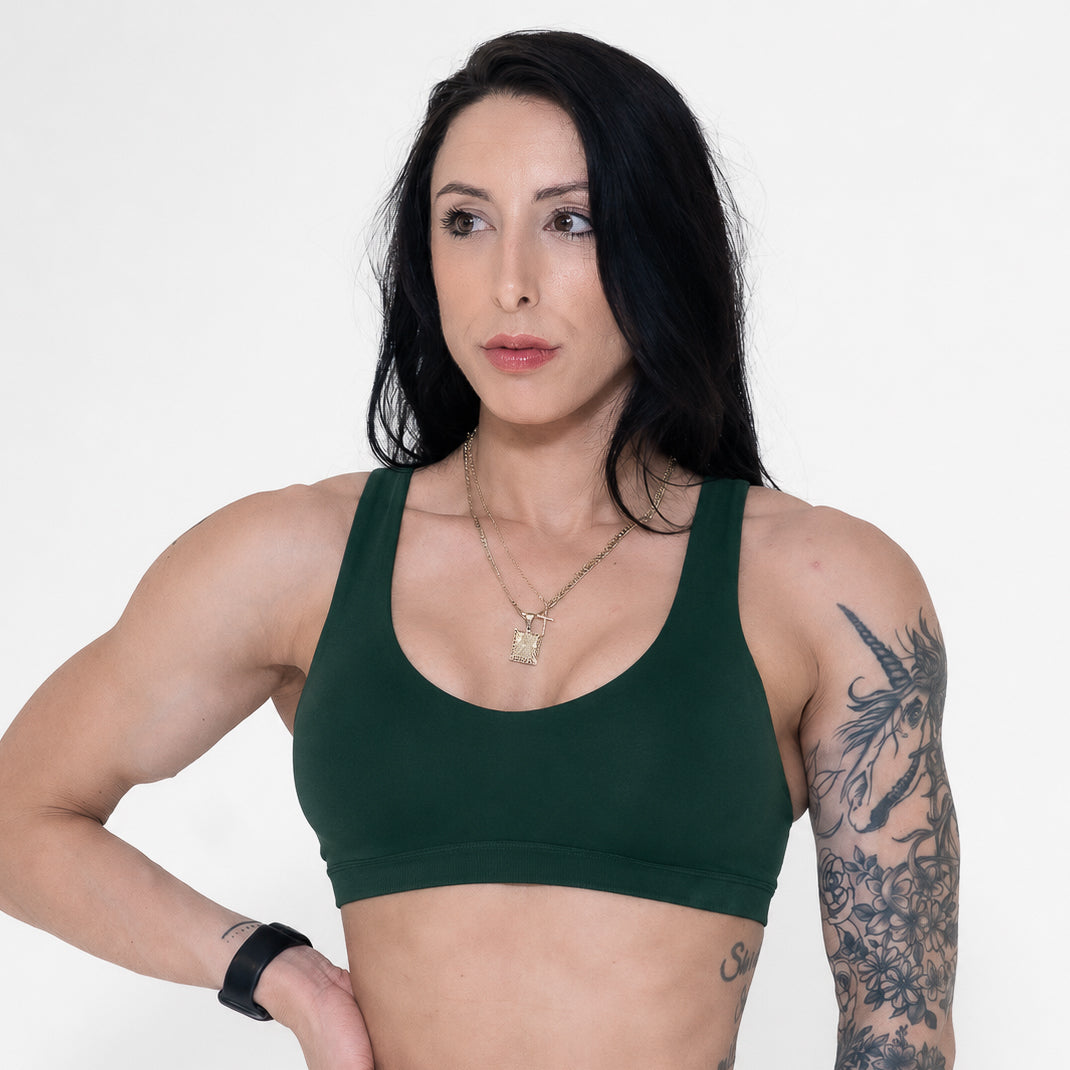 Woman wearing a green sports bra against a white background
