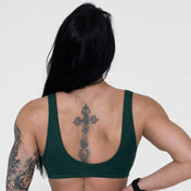 Person wearing a green sports bra with a white background